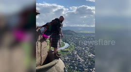 Thrill-seekers dressed in kilts base jump from top of William Wallace Monument in Stirling