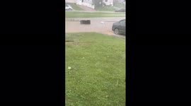Trash can floats down flooded street in Maryland