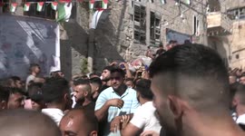 People evacuate Palestinian youth following a raid by Israeli forces of a house