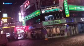 Store signs flicker as power supply is hit during floods in Seoul, South Korea