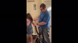Creative father does his daughter's hair using a vacuum cleaner