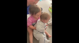 Overprotective toddler doesn't let dad hold her baby brother