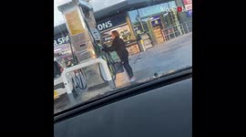 Strange woman stops by gas station to fill up a shopping bag with fuel