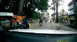 Tree branch falls in front of oncoming drivers on busy road in Thailand