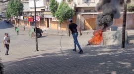 Palestinian protesters hurl stones towards Israeli forces following a demonstration against settlements