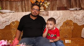 Palestinian's wife killed by an Israeli air strike during the latest Israel-Gaza fighting plays with his son