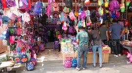 Palestinians shop during preparation for the new school year at a market