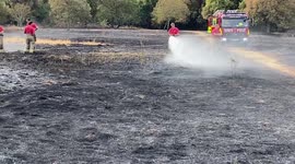 London Fire Brigade extinguish a wildfire in a field in Enfield