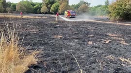 London Fire Brigade extinguish a wildfire in a field in Enfield as a drought hits London