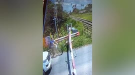 Impatient cyclist dodges oncoming train at level crossing in Thailand