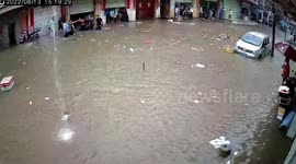 Neighbours rescue woman who fell into sewer on flooded road in southern China