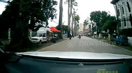 Huge tree branch falls in front of oncoming drivers on busy road in Thailand