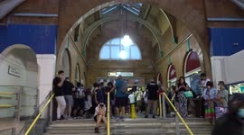 Passengers cower inside Earls Court station as heavy rain disrupts heatwave