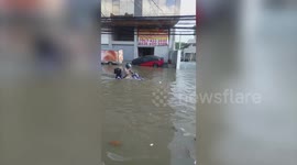 Motorcycle rider gets stuck on flooded road in the Philippines