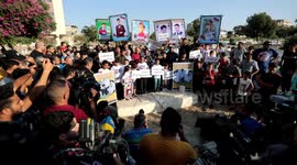 Relatives of five Palestinian children who killed during the latest fighting between Israel-Gaza hold placards during a rally next to their graves