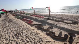 A Sand sculpture includes 17 names of Palestinian children who were killed during the latest fighting between Israel and Gaza, on the beach of Gaza's sea
