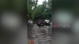 Torrential lane forced commuters to wade through knee-deep water in London this afternoon