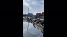 People walking on the central reservation barriers to get over the water flooding