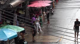 Tourists brave the rain as they return to Bangkok, Thailand
