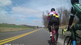 Large dog races onto the road and jumps at cyclist. Dog jumps at cyclists