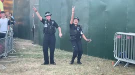 Two police officers dance along to Scouting For Girls at Camp Bestival, Shropshire. Friday