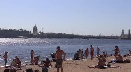Local people are sunbathing in the centre of St Petersburg, opposite of the Hermitage museum, Russia