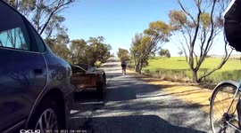 Car towing trailer close passes cyclists and blasts horn. Dangerous driving caught on camera