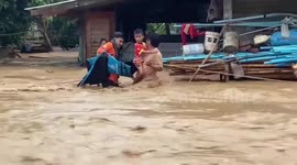Stranded dad carrying son rescued from waist-deep floods surging through northern Thailand