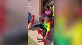 Kids play hilarious sports day game eating banana with string tied to their feet
