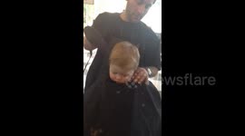 Little boy dozes at barber's