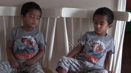 Adorable twins fall asleep at same time with heads forward