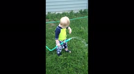 Boy Sprays Self With Hose