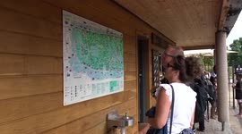 Visitors studyng map of Diana Memorial Playground as they enter adventureland in Kensington Gardens