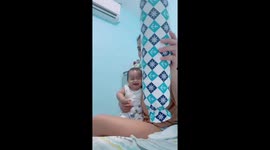 Baby girl laughs uncontrollably as mum picks up pillow