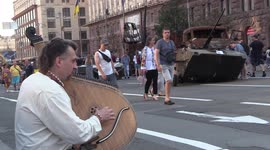 Ukrainian man playing traditional song amongst destroyed tanks during Independence Day celebrations in Kyiv