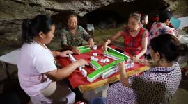 Villagers play cards and mahjong IN CAVE to escape heatwave in southern China