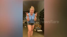Heartbroken woman sifts through flooded living room in Dallas, Texas
