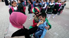 Palestinian students hold the picture of the Lian Al-Shaer who died of her injuries from an Israeli air strike