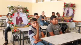 Palestinian students put the pictures of their colleagues who where killed Israeli air strikes on their bench during the first day of the new year study