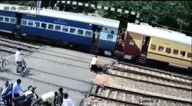 Man and his bike almost hit by high-speed train at railway crossing in India