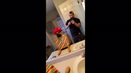 Dog looks at himself in the mirror after owner dresses him up as a Christmas present