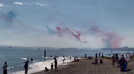 Awesome display by RAF Red Arrows at Bournemouth Air Show as sunseekers watch on