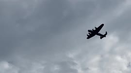 Avro Lancaster bomber flies over the heads of spectators on the beach at the Bournemouth Air Festival