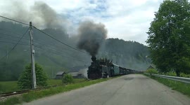 Driver in Romania, distracted by stunning rural steam train, almost crashes into it