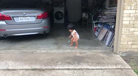 One year old climbs over gaps of pavement