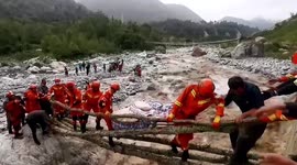 Firefighters use tree trunks to form bridge to transport injured people across river after earthquake strikes China