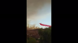 Airtanker drops red fire retardant to fight huge blaze in Hemet, California