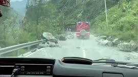 Huge rock crashes onto road, narrowly missing passing fire engines in China