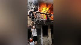 Brave men carry elderly woman out of burning house in China