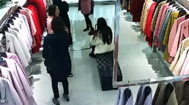Woman caught on camera sneaking coat under her top in clothes shop
